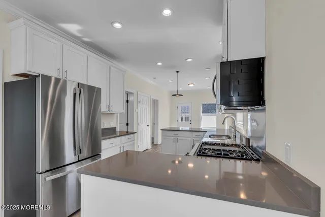 a kitchen with stainless steel appliances a refrigerator and a stove top oven