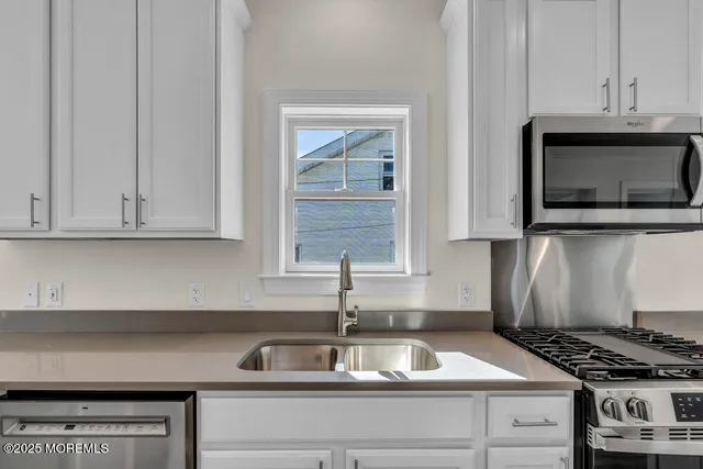 a kitchen with granite countertop a stove and a sink