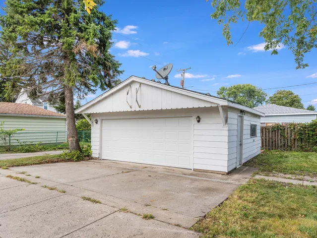 a view of a white house with a yard and garage