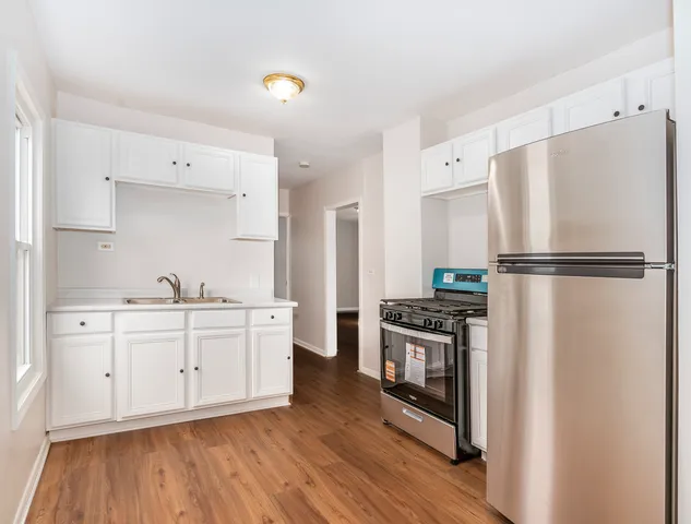 a kitchen with white cabinets and stainless steel appliances