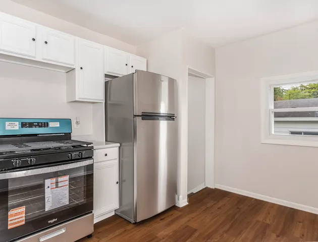 a kitchen with a refrigerator stove and wooden cabinets