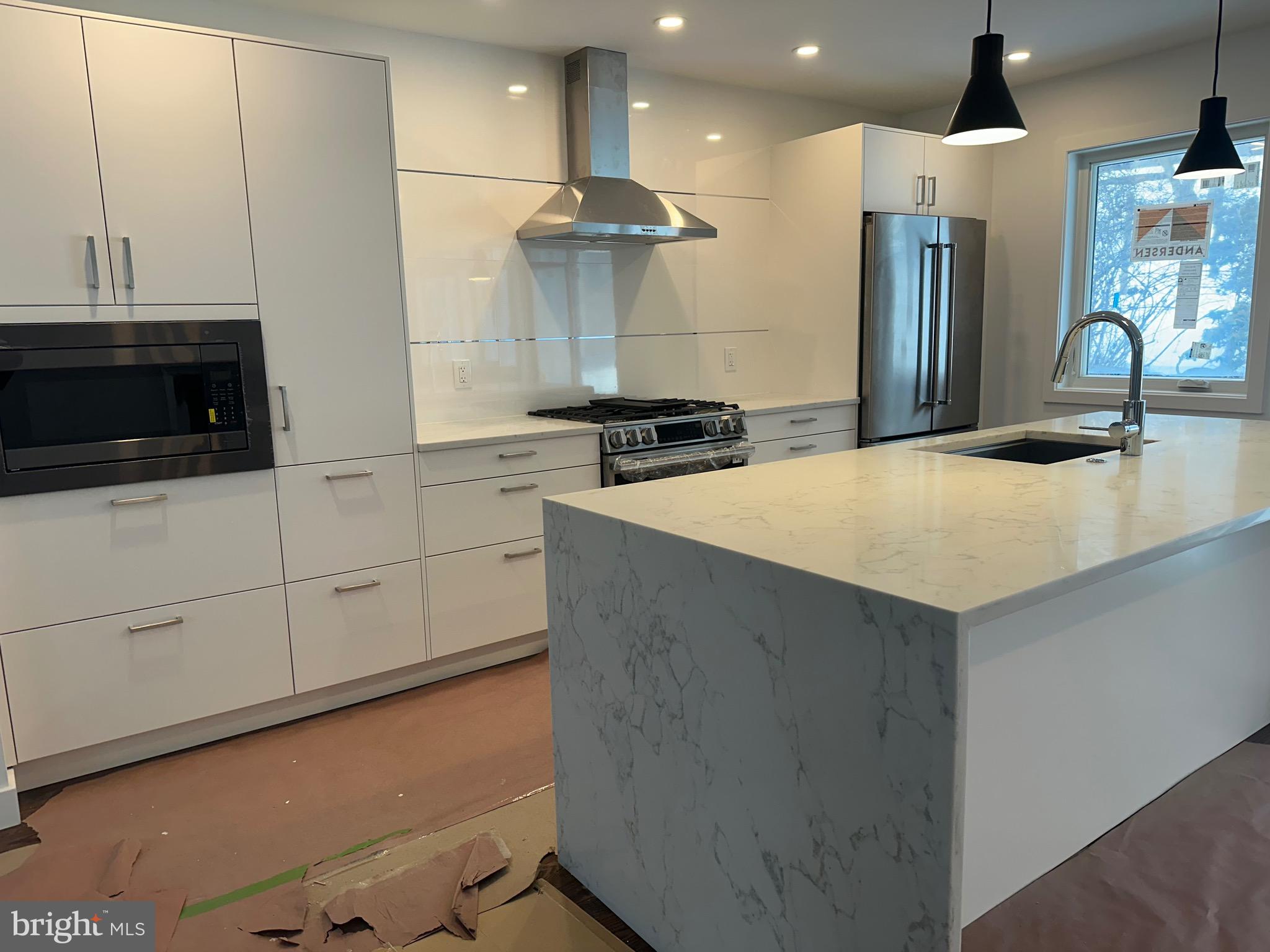 a kitchen with stainless steel appliances a microwave a stove and a refrigerator