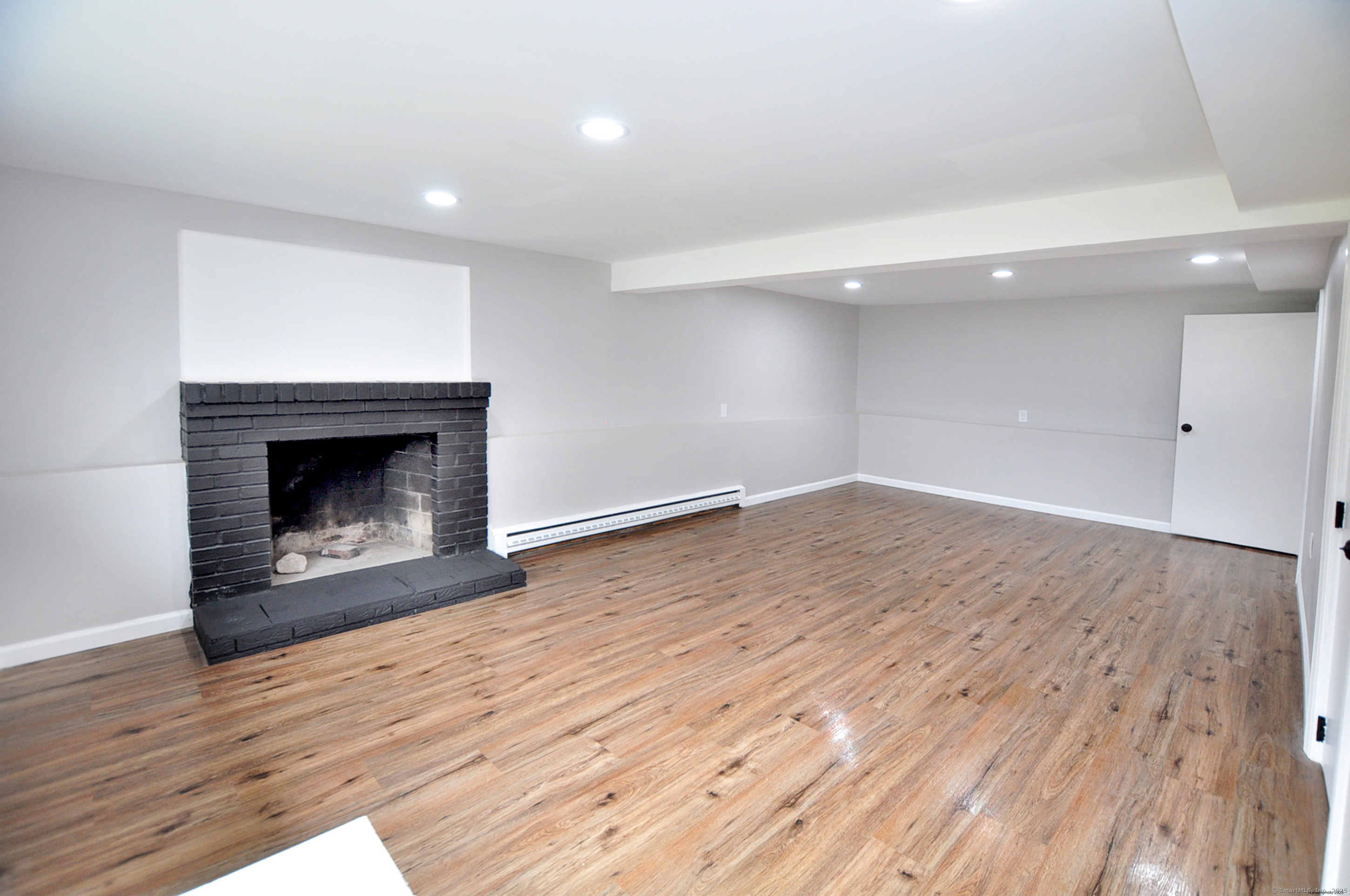 4 Kimann Drive Plymouth, CT 06786 - Photo 19 of 25 an empty room with wooden floor and fireplace