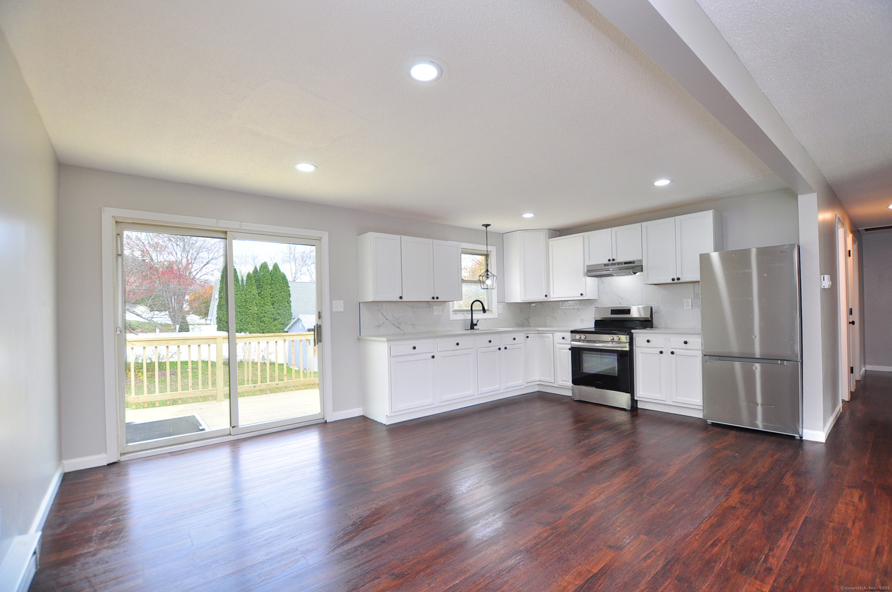 4 Kimann Drive Plymouth, CT 06786 - Photo 2 of 25 a large white kitchen with stainless steel appliances granite countertop a stove a refrigerator a sink and a large window with wooden floor