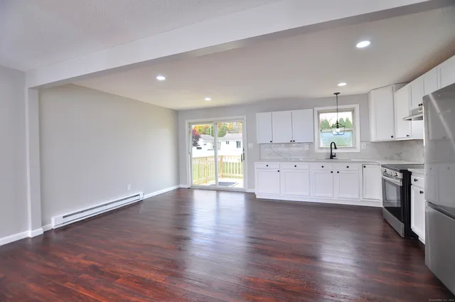 a large kitchen with hardwood floor a window and a sink