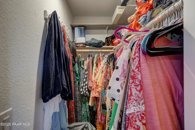a view of walk in closet with clothes