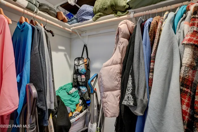 a view of walk in closet with clothes and shoes