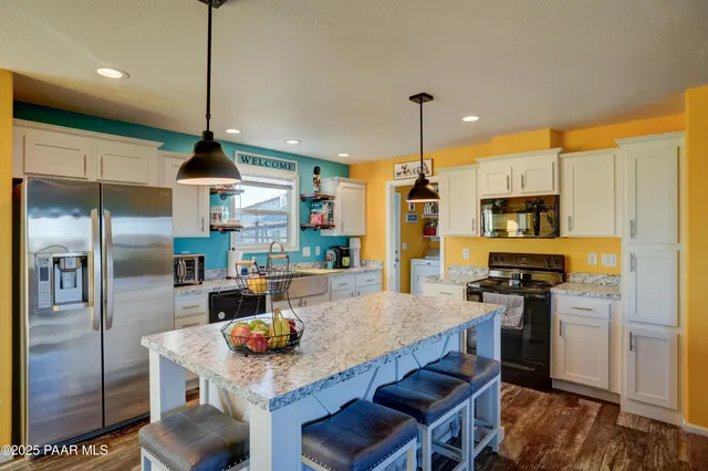 a kitchen with stainless steel appliances granite countertop a sink a stove and refrigerator