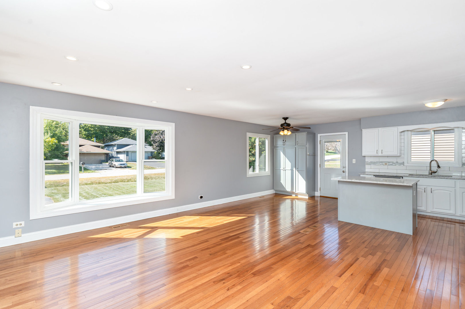 S045 Pleasant Hill Road Wheaton, IL 60187 - Photo 3 of 31 a view of an empty room with window wooden floor and a kitchen