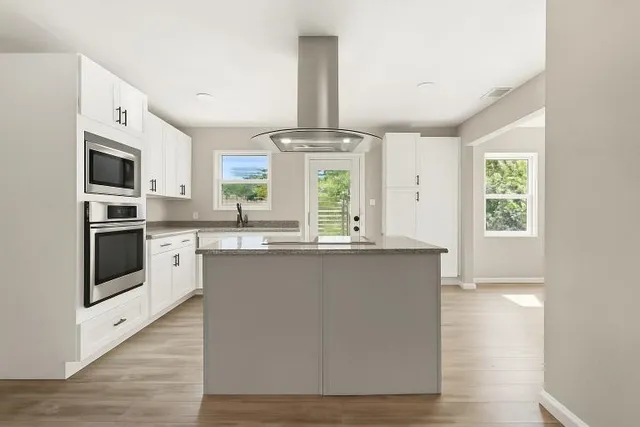 a kitchen with granite countertop a sink stove and refrigerator