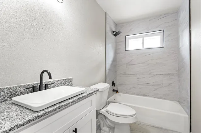 an empty room with a window and a ceiling fan