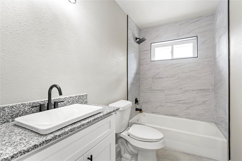 2116 Ridgeway Street Arlington, TX 76010 - Photo 13 of 21 a bathroom with a granite countertop sink a toilet and a bathtub