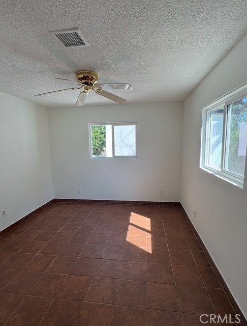 7514 Beckford Avenue Reseda, CA 91335 - Photo 11 of 20 an empty room with windows and ceiling fan