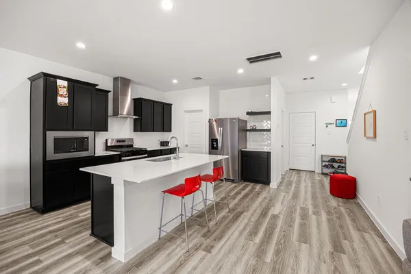 a kitchen with a sink a counter top space stainless steel appliances and cabinets