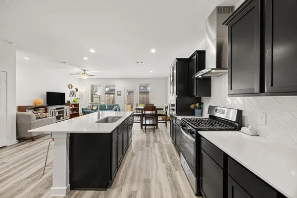 a kitchen with stainless steel appliances a stove refrigerator sink and cabinets