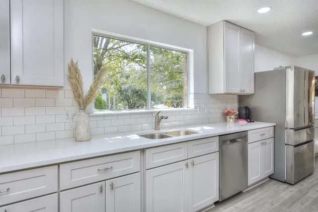 a kitchen with a sink a window and cabinets
