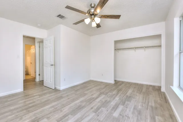 an empty room with a window and wooden floor