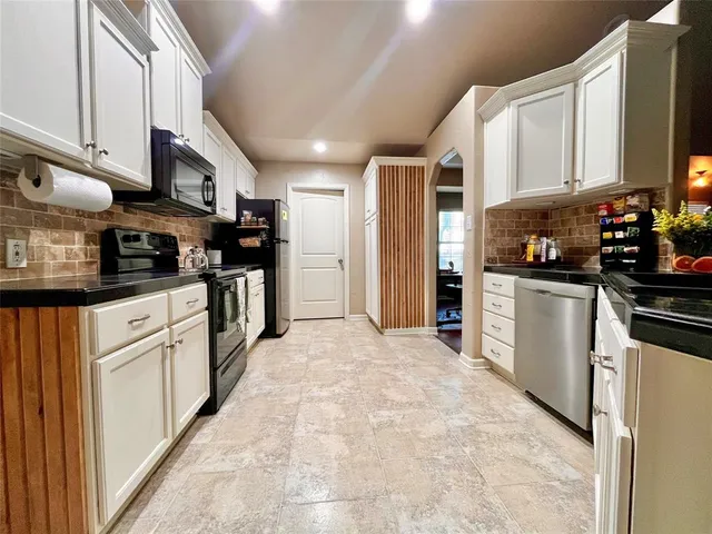 a kitchen with stainless steel appliances granite countertop a refrigerator a stove top oven a sink and dishwasher