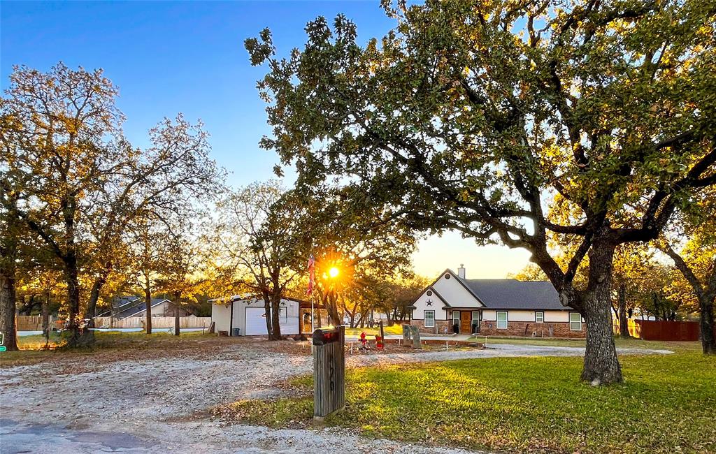 420 Sessums Road Springtown, TX 76082 - Photo 2 of 40 a front view of a house with a yard garage and outdoor seating