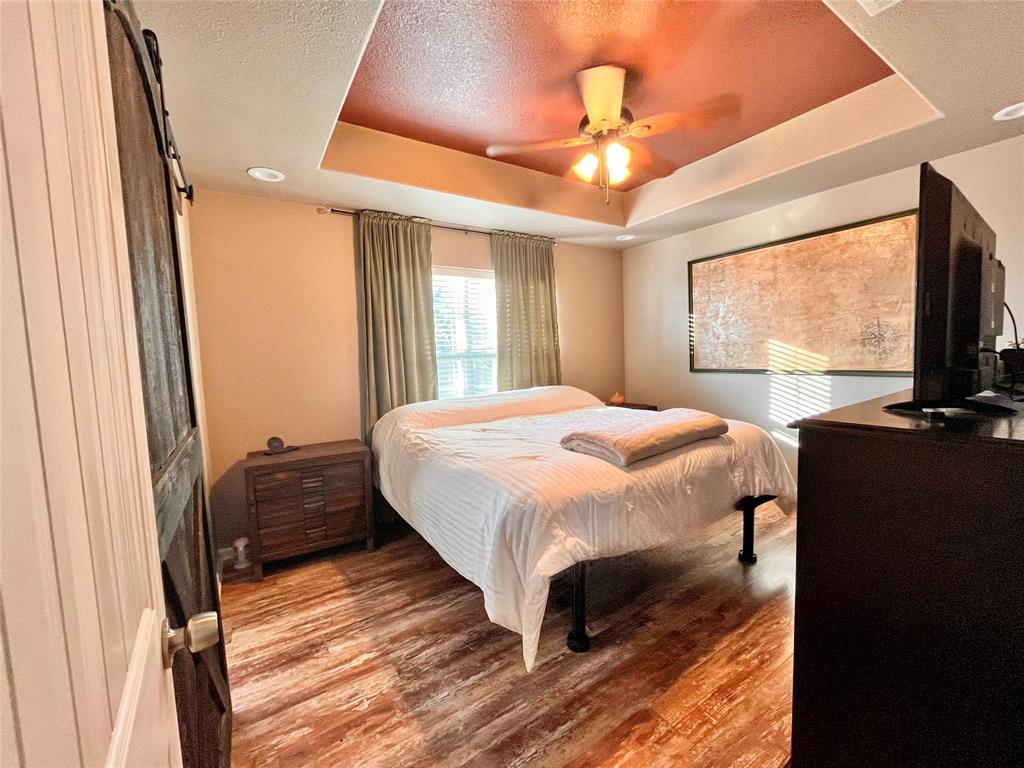 420 Sessums Road Springtown, TX 76082 - Photo 20 of 40 a bedroom with a bed and a flat tv screen on dresser