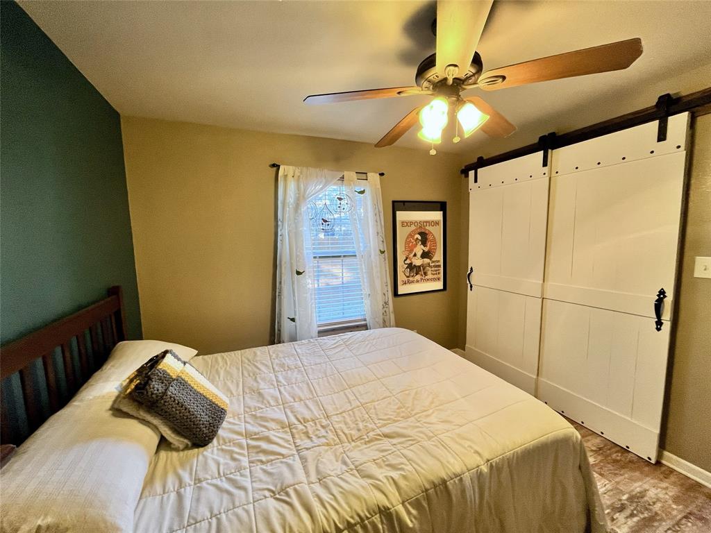 420 Sessums Road Springtown, TX 76082 - Photo 30 of 40 a bedroom with a bed and a chandelier