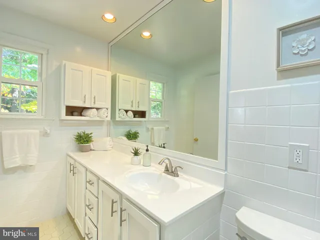 a bathroom with a double vanity sink toilet and a mirror