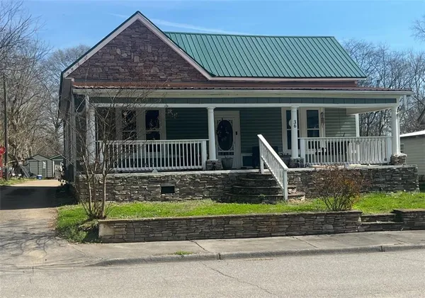 a front view of a house with a garden and plants
