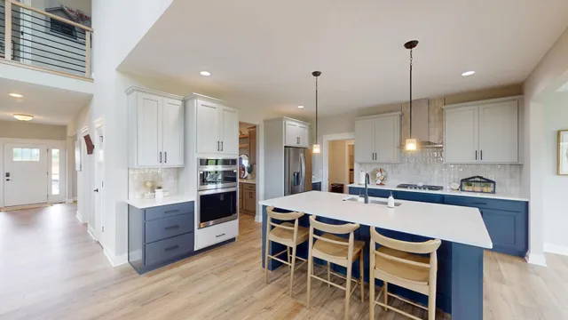 a kitchen with a table a sink stainless steel appliances and cabinets