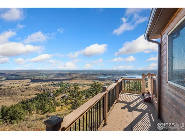a view of balcony with wooden floor & fence