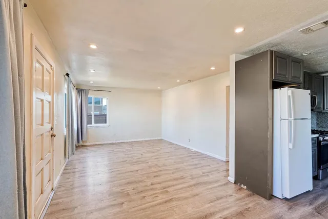 a view of hallway with furniture and a refrigerator