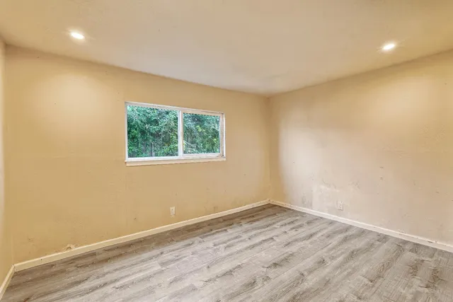 a view of a room with wooden floor and window