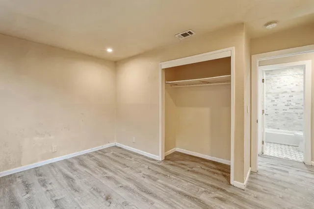 a view of empty room with wooden floor and entryway