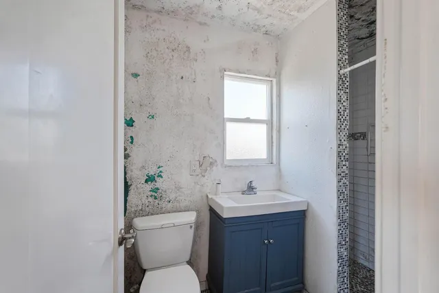 a bathroom with a toilet a sink and a window