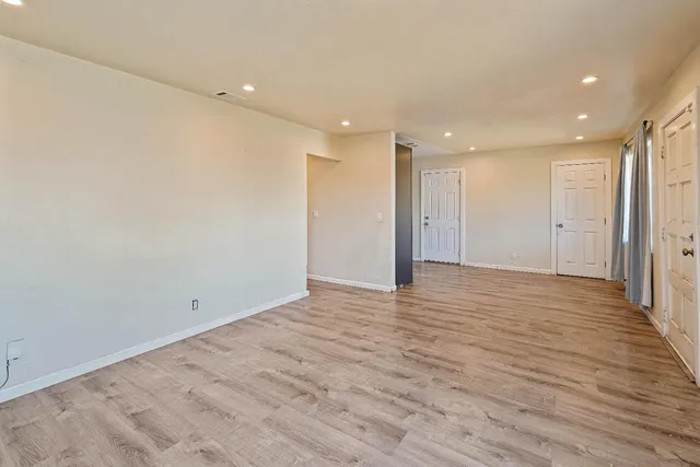 a view of an empty room with wooden floor