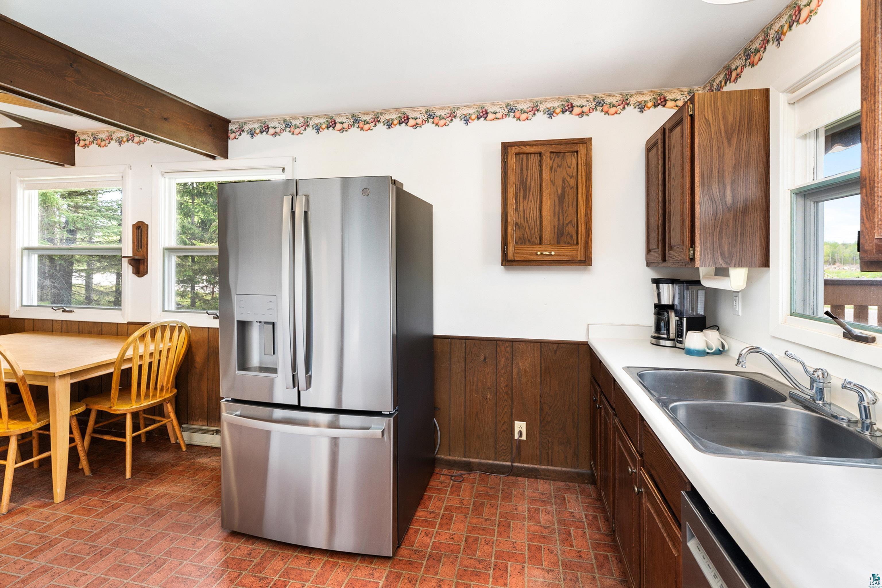 4808 Midway Road Duluth, MN 55811 - Photo 8 of 57 Stainless steel French door refrigerator, wood-finish cabinetry, and solid surface countertops