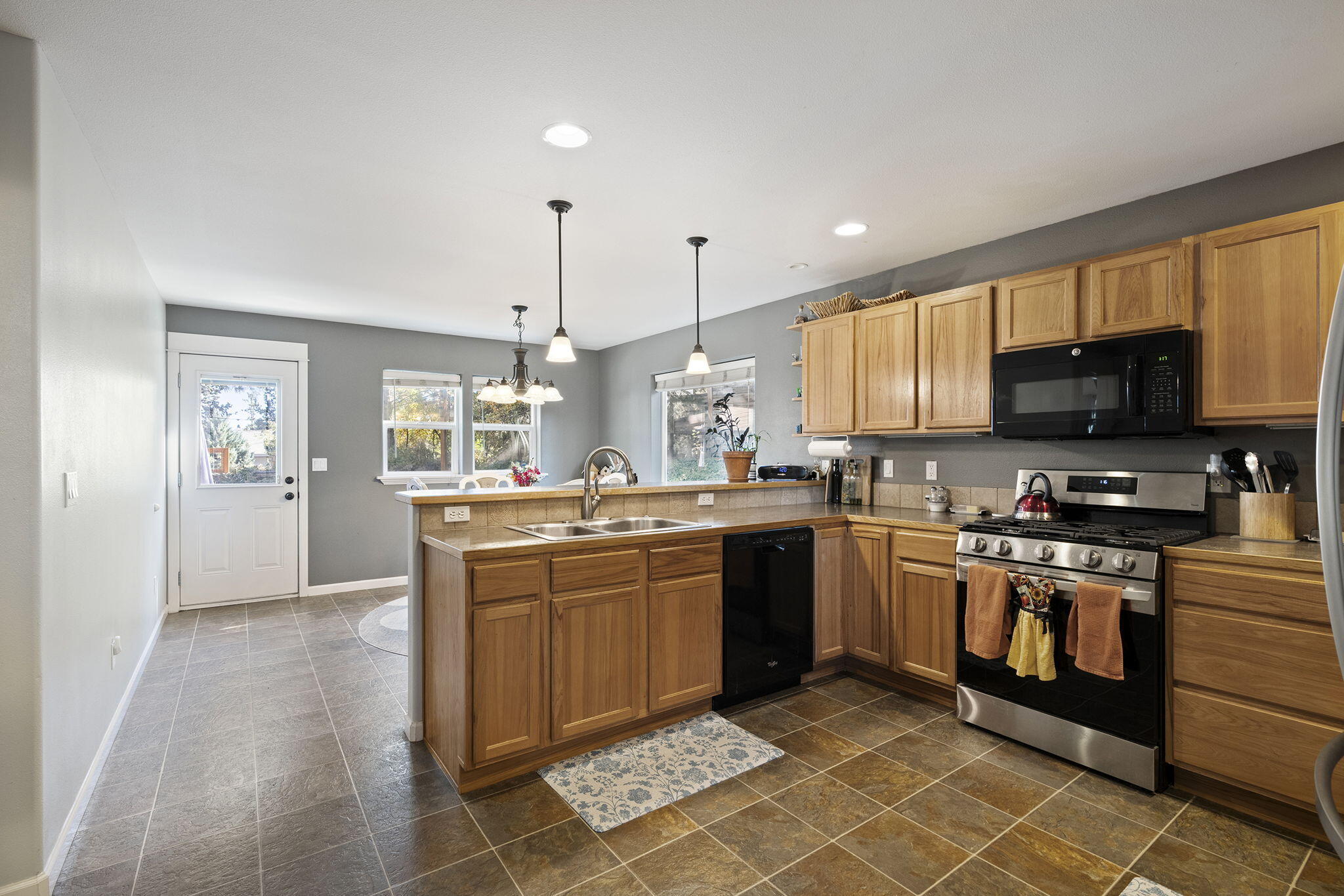 62906 Bilyeu Way Bend, OR 97701 - Photo 8 of 100 a kitchen with stainless steel appliances granite countertop a stove top oven a sink dishwasher and a refrigerator
