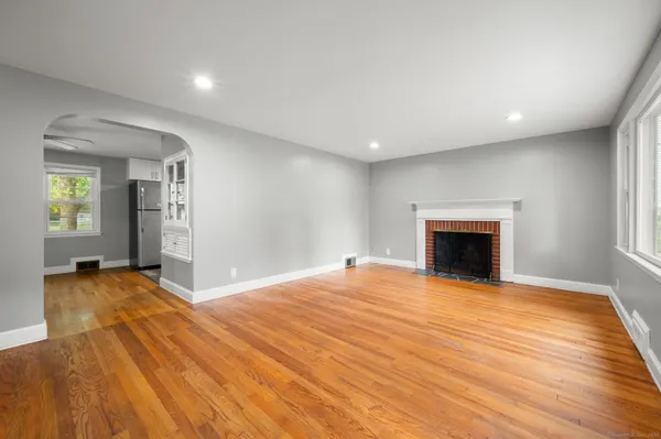 a view of empty room with wooden floor and fireplace