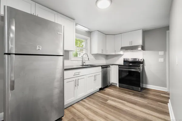a kitchen with a refrigerator and a stove top oven