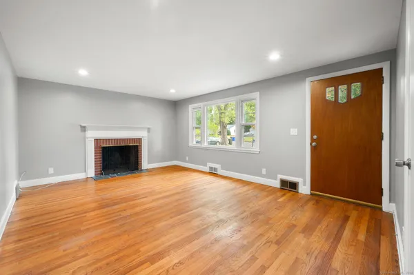 an empty room with windows and fireplace