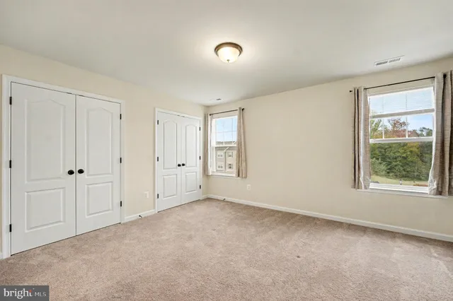 an empty room with windows and closet