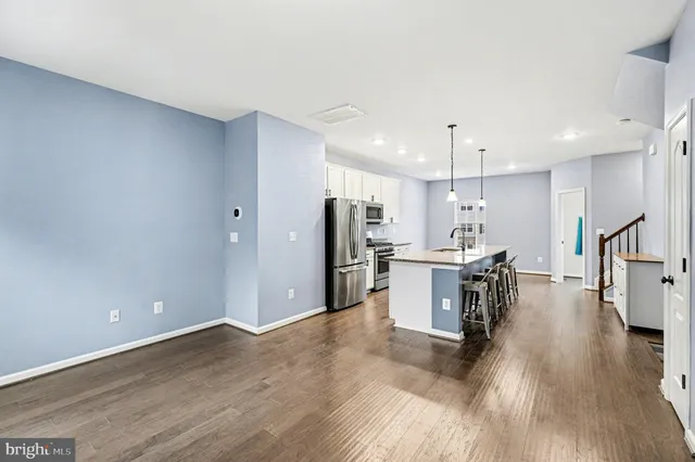 a view of kitchen with refrigerator microwave and wooden floor