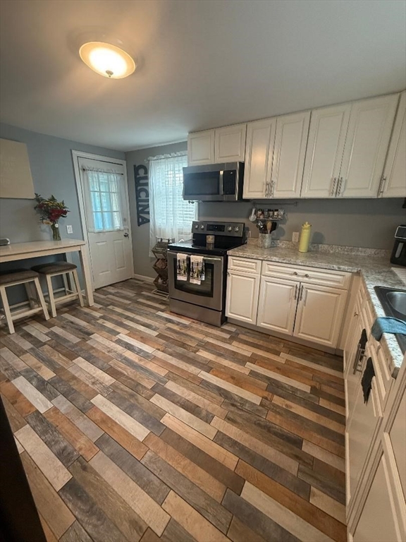 66 Powell Avenue Springfield, MA 01118 - Photo 11 of 31 a kitchen with granite countertop a stove a sink and a refrigerator