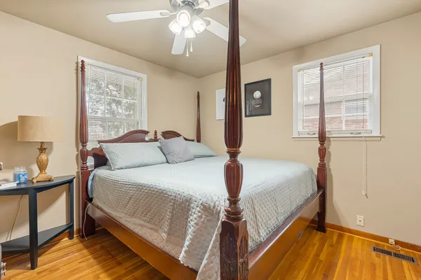 a bedroom with a bed and wooden floor