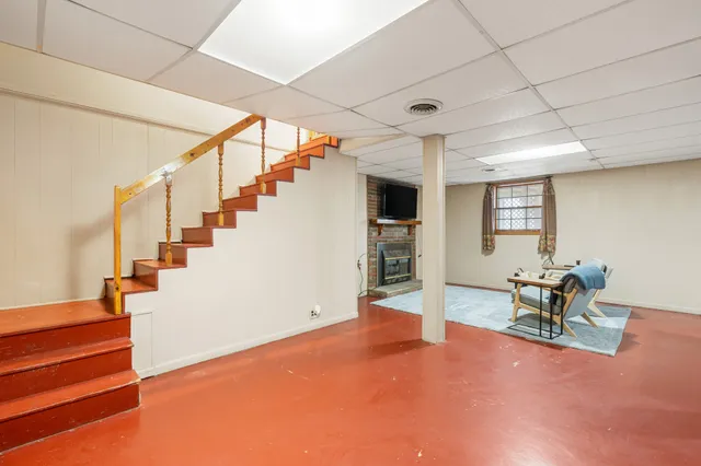 a view of an empty room with stairs and furniture