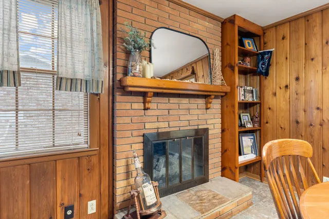 a living room with a fireplace furniture a rug and a window