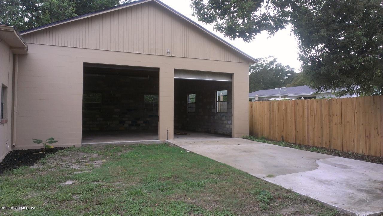 3436 Rogero Road Jacksonville, FL 32277 - Photo 5 of 6 a view of backyard with potted plants and a large tree