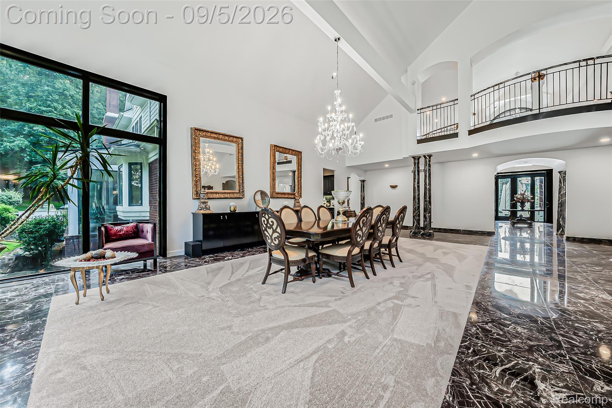 2785 Cranbrook Ridge Court Rochester, MI 48306 - Photo 29 of 97 Grand interior space featuring high vaulted ceilings, expansive floor-to-ceiling windows, polished dark stone flooring, and a second-story balcony with wrought iron railings