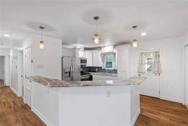 a kitchen with granite countertop a refrigerator and a sink