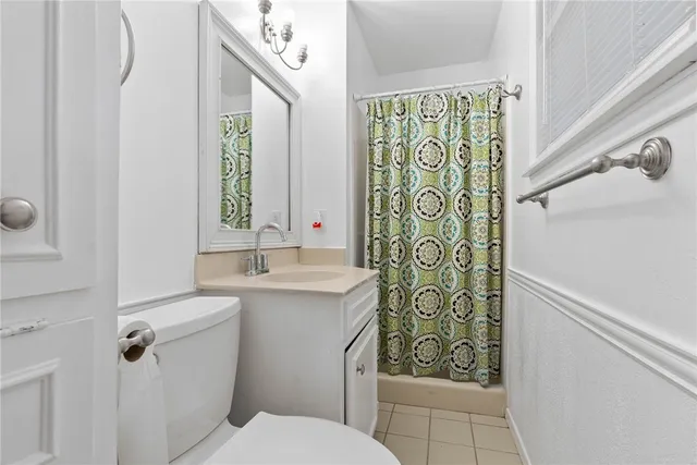 a bathroom with a granite countertop sink a toilet and shower