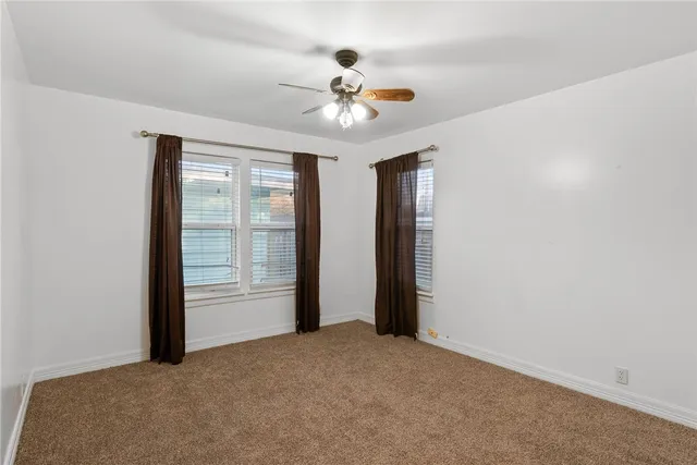 a view of an empty room with a ceiling fan